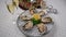 Fresh oysters on ice rotating, Christmas New Year decoration, glasses of champagne. Close up