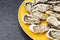Fresh oysters ready to be eaten raw. Oysters on a yellow plate and a black stone. Raw fish with oysters, luxurious dinner and