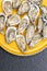 Fresh oysters ready to be eaten raw. Oysters on a yellow plate and a black stone. Raw fish with oysters, luxurious dinner and