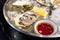 Fresh oysters with sauce bowl and lemon on ice