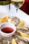 Fresh oysters in a white plate with ice and lemon. Open Oysters and glass of white wine. Tasty Oysters On Ice