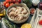 Fresh Pacific white shrimp or king prawn in round bowl on dark background with herbs and olive oil. Top view, close-up