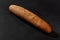 Fresh, palatable baked grain bread against black background with copy space. Rural cuisine or bakery. Close-up