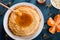 Fresh pancakes with honey, maple syrup, cottage cheese and tangerines. Wooden background. Top view