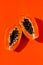 Fresh papaya exotic tropical fruit on orange background. Sun day light illumination. Minimalistic summer flat lay