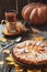 Fresh pastry apple pie with sugar powder on wooden table with hot drink tea and cinnamon on background. Homemade cake Thanksgiving