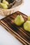Fresh pears in a wooden board and basket on a table. Seasonal Harvest.