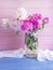 Fresh peony bouquet in a vase on wooden flower