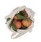 Fresh picked oranges in reusable, recyclable fabric shopping tote bag, isolated on white. For environmentally friendly