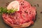 Fresh piece of meat large beef steak on the bone ossobuco with a sprig of rosemary on a black background.