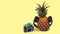 fresh pineapple with black headphones and wlakman yellow background