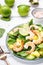 Fresh pineapple shrimp salad with spinach, avocado and lime on white wooden table, top view. Healthy eating, balanced, clean diet