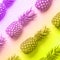 Fresh pineapples on vibrant rainbow gradient background. Top View. Pop art design, creative concept. Copy Space. Neon pineapple