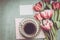 Fresh pink pale tulips bunch with heart, blank paper and cup of coffee , top view.