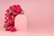 Fresh pink roses as arch, empty rounded door as podium on abstract pink scene mockup for presentation cosmetic products or goods.