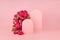 Fresh pink roses as arch, empty rounded doors as two podiums on abstract pink scene mockup for presentation cosmetic products.