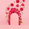Fresh pink roses as framing of arch with green leaves and buds fly as stream on abstract pink scene mockup for presentation.
