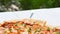 Fresh pizza lying on a table in an outdoor cafe, divided into slices. Closeup photography.Horizontal banner