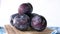 Fresh plums in a bowl on table