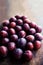 Fresh plums on a dark wood background. Top view image. Ripe Plu