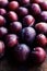 Fresh plums on a dark wood background. Top view image. Ripe Plu