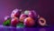 Fresh plums on purple background