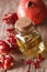 Fresh pomegranate seed oil in a glass bottle macro. vertical