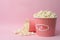 Fresh popcorn on pink background. Cinema snack