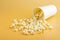 Fresh popcorn spilled out of thewhite box on a orange background. Cinema snack concept. The food for watching a movie and