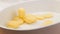 Fresh potato slices falling in oven dish in slow motion