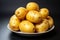 Fresh potatoes in a plate on a dark background