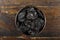 Fresh prunes in wooden bowl. Dried plums