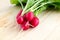 Fresh radishes, Raphanus sativus, on wooden plate