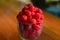 Fresh raspberries in a glass on the table. Healthy and vitamine food