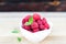 Fresh Raspberry Fruits In White Bowl on Wooden Table