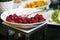 Fresh raspberry plate with spoon on black kitchen table, close-up