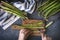 Fresh raw asparagus on stone background. Women female hands cut asparagus on cooking board.