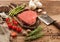 Fresh raw barbeque braising beef steak on chopping board with asparagus and garlic with cherry tomatoes and salt with pepper on
