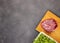 Fresh raw beef on a chopping Board with vegetables and microgreens on a black marble background, top view