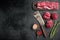 Fresh Raw Beef steak Mignon whole cut , with old butcher cleaver knife, on black stone background, top view flat lay, with copy