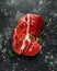 Fresh Raw braising steak on black background with rosemary, pepper, salt