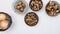 Fresh raw brown mushrooms in a bowl and yellow onion in basket, close up view from above