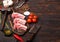 Fresh raw butchers lamb beef cutlets on chopping board with vintage meat hatchet and hammer on wooden background.Salt, pepper and