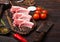 Fresh raw butchers lamb beef cutlets on chopping board with vintage meat hatchet and hammer on wooden background.Salt, pepper and