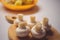 Fresh raw champignons lie on a wooden board, side view