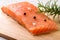 Fresh raw chilled salmon fillet, pepper grain, sea salt and rosemary on a wood cutting board. Healthy eating, seafood recipe