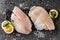 Fresh raw fillet white fish Pangasius with spices and lemon on dark stone background