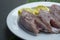 Fresh raw fish on white plate with green leaf and lemon