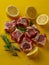 Fresh Raw Lamb Chops with Rosemary and Lemon on Bold Yellow Background for Culinary Concepts