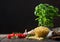 Fresh raw maccherono elbows pasta in glass bowl with basil plant  oil and tomatoes with garlic and pepper on wooden background